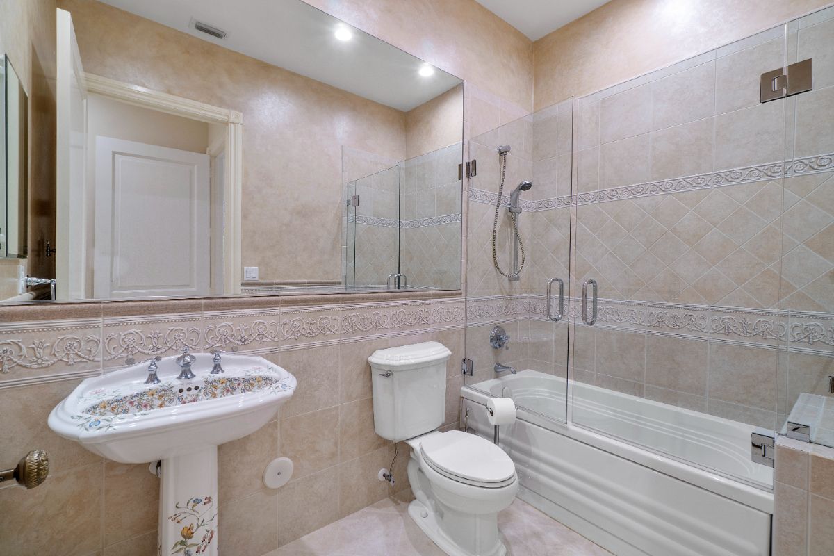 The bedroom's bathroom features a built-in bathtub on the shower cubicle.