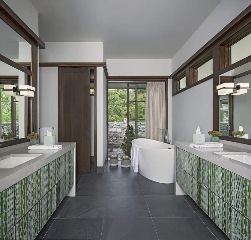 The bathroom showcases a tropical vibe with its decorative tiles cladding the vanities.