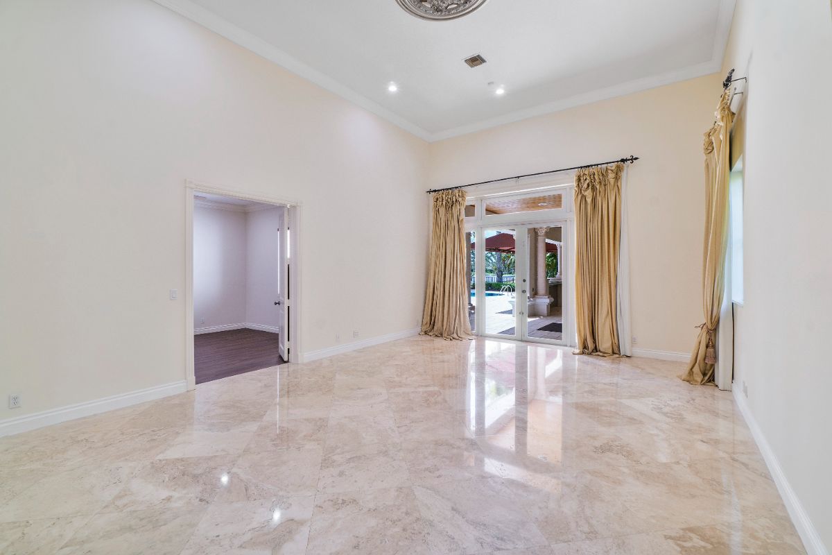 The bedroom space has access to the backyard and the outdoor kitchen, and the room has a gold-colored curtain giving off a luxurious feel.