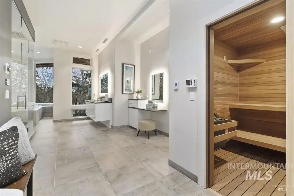 The bathroom features a sauna and a floating vanity and the mirrors feature accent backlighting giving off a glowing effect.