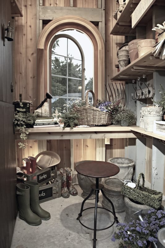 The storage shed is filled with garden tools and a built-in desk.