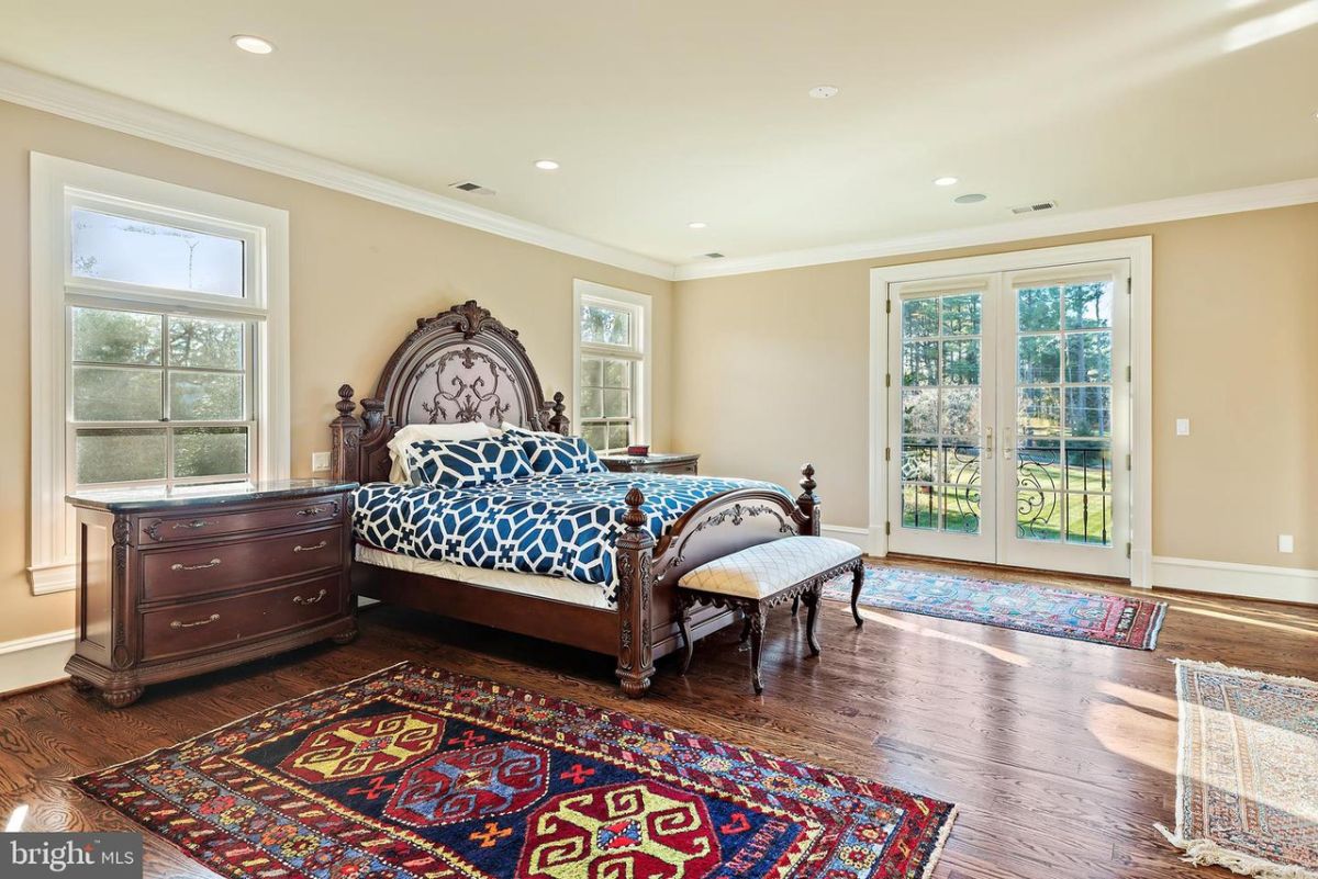 The master suite has an area rug and a bed made of solid wood, giving the room a rustic feel.