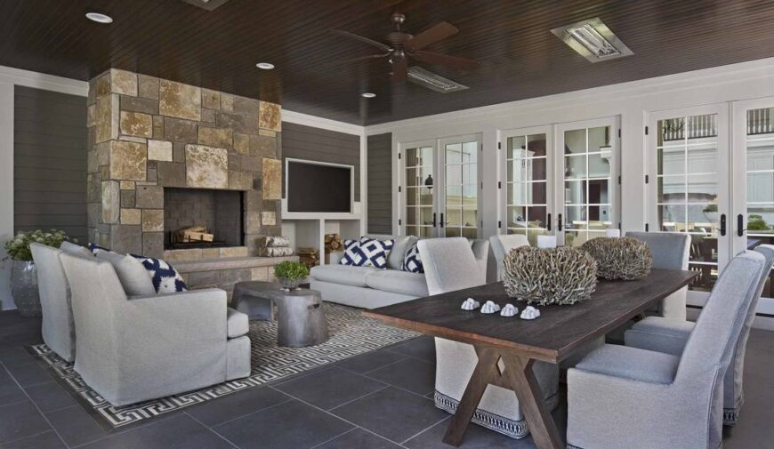 The covered porch is warmed by a large fireplace clad in stones.