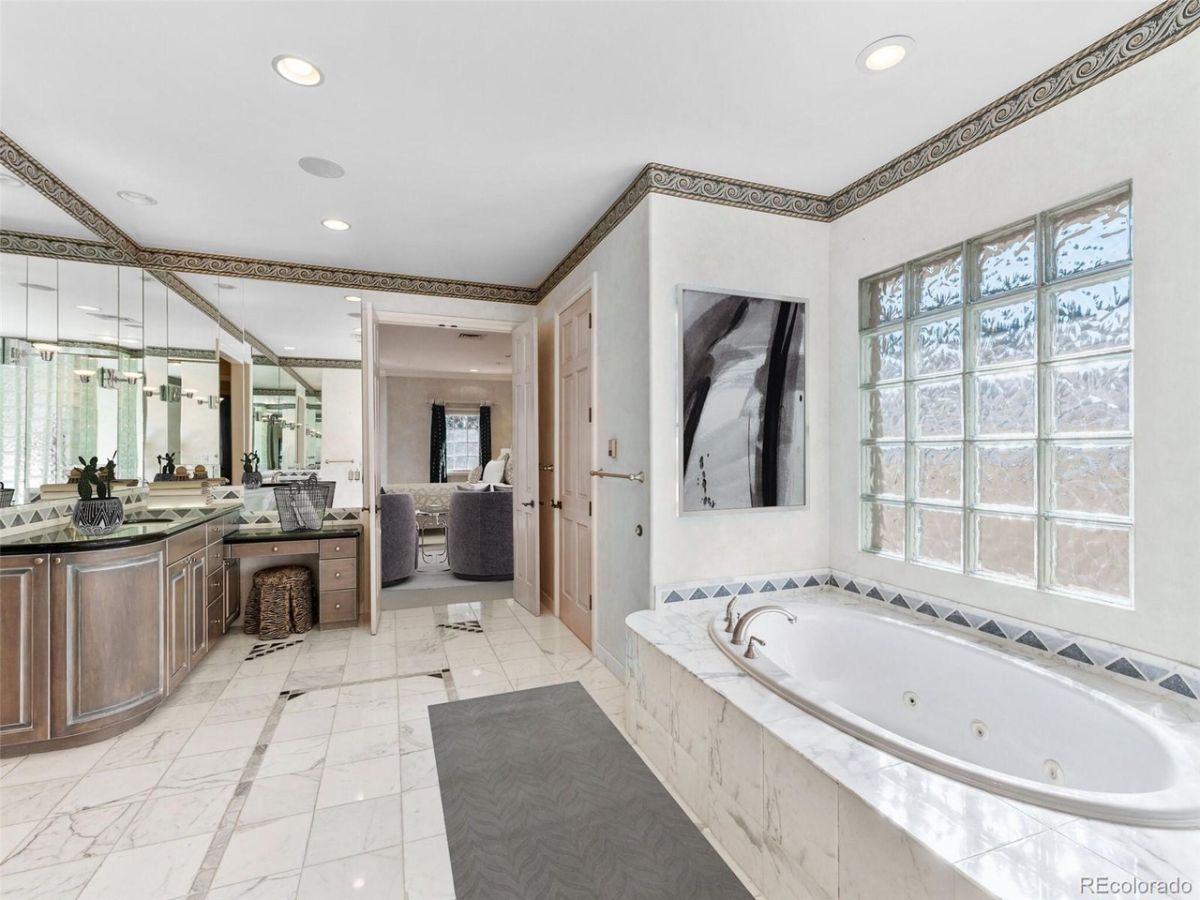 The master suite's bathroom features a built-in bathtub and a vanity with a marble top.