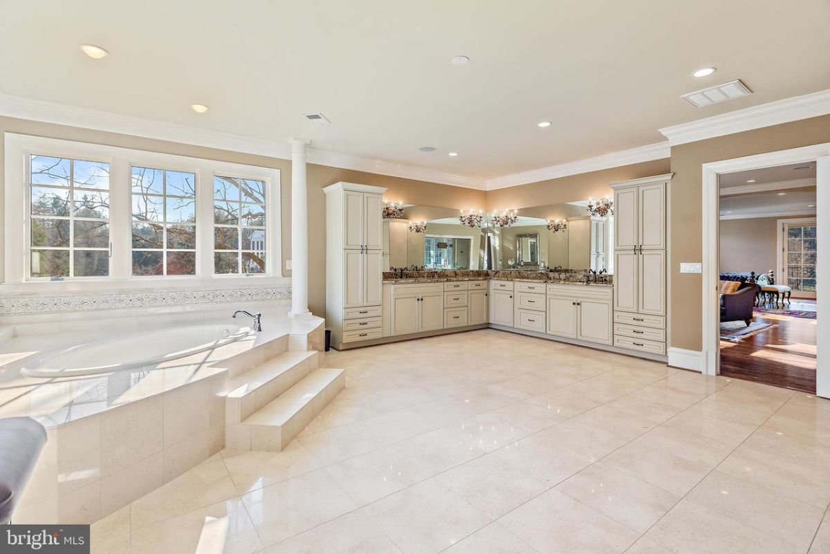 The master bathroom features a luxurious bathtub and a large vanity.