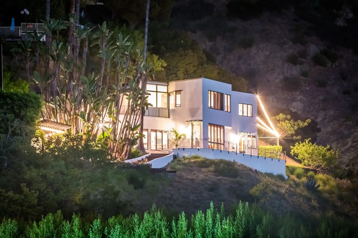 The view of the house during the night together with the mountains.