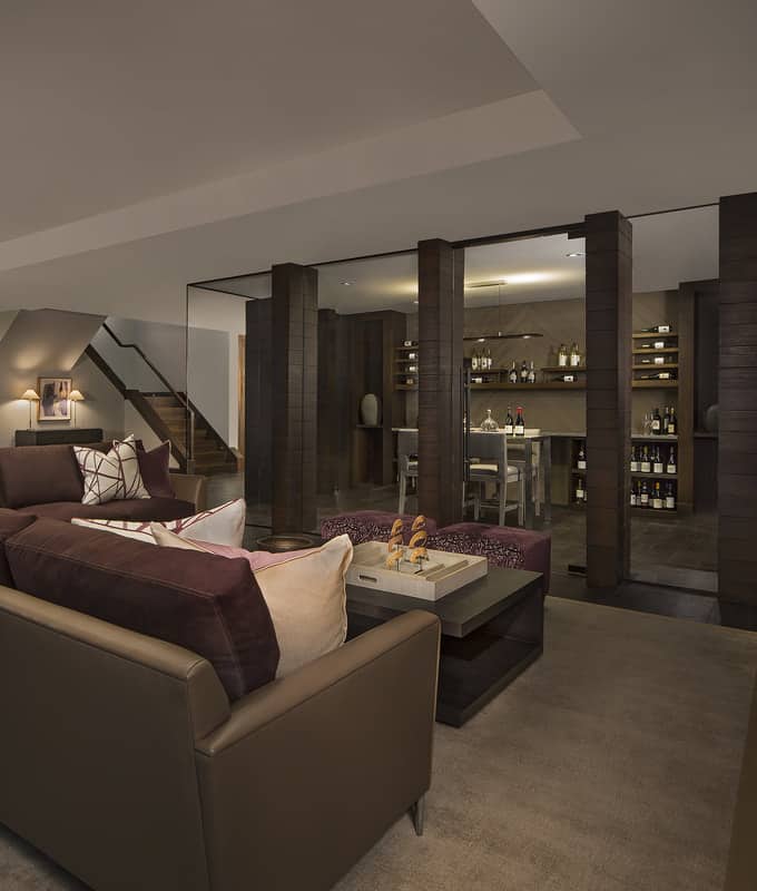 The basement's living area overlooks the glass-enclosed wine cellar.