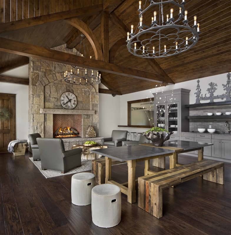 This open living space radiates a rustic charm showcasing lots of wooden elements plus a stone fireplace.