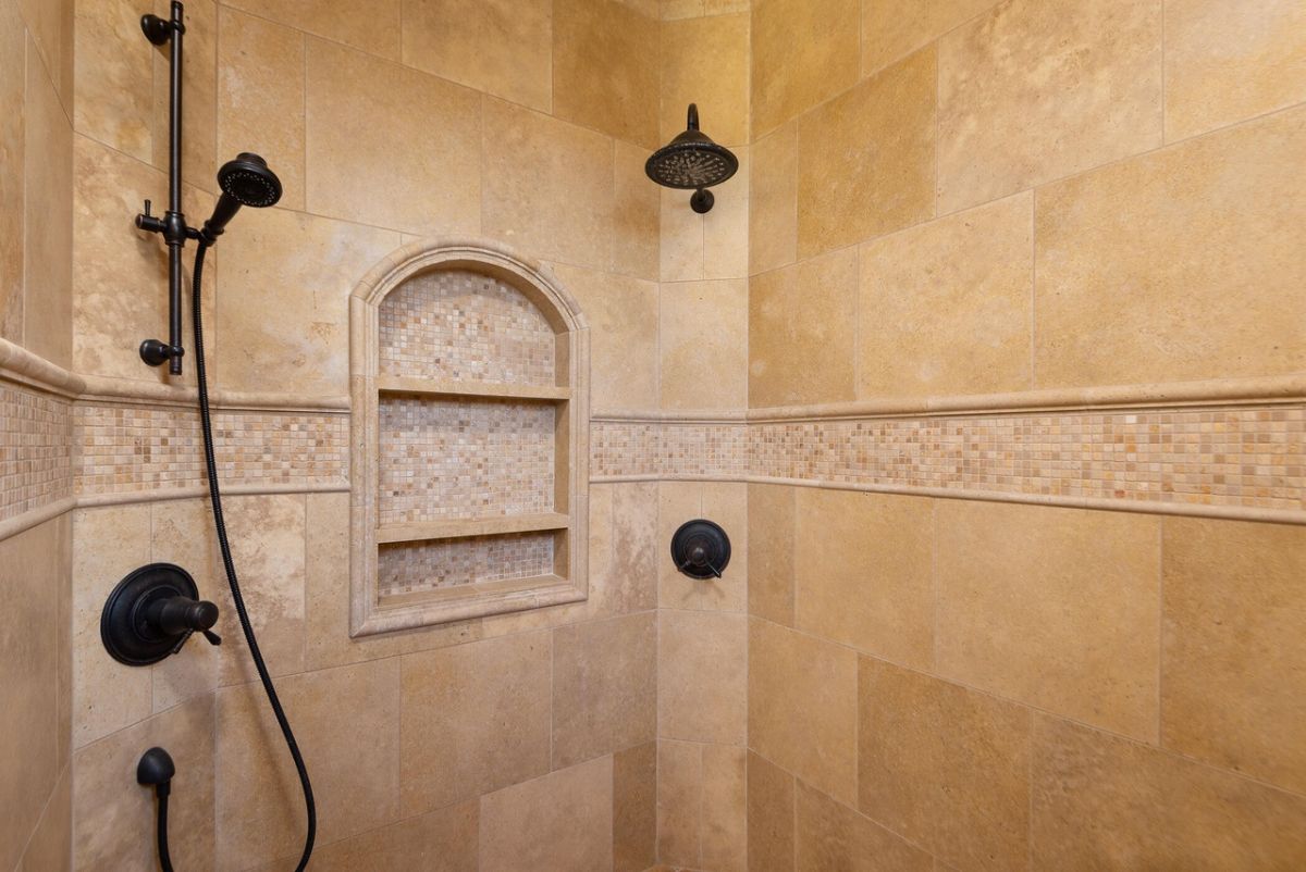 The bathroom shower is enclosed with tile walls.