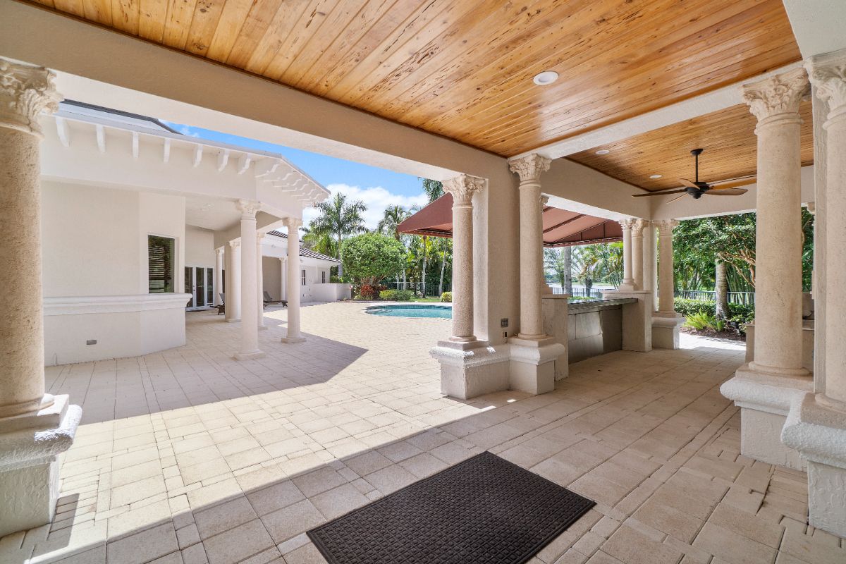 The outdoors features concrete pavement and an outdoor kitchen.