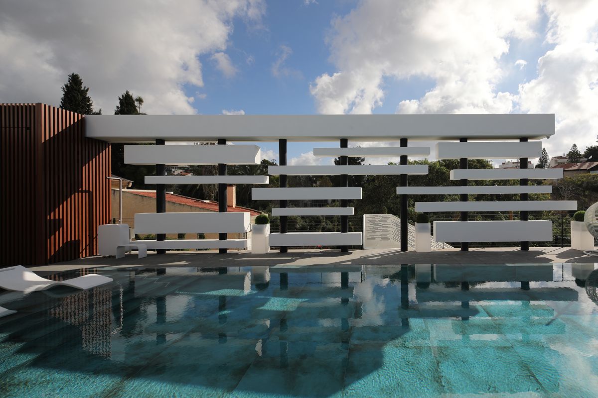 The swimming pool's vertical wooden strips, steel posts, and horizontal rectangular concrete cubes.