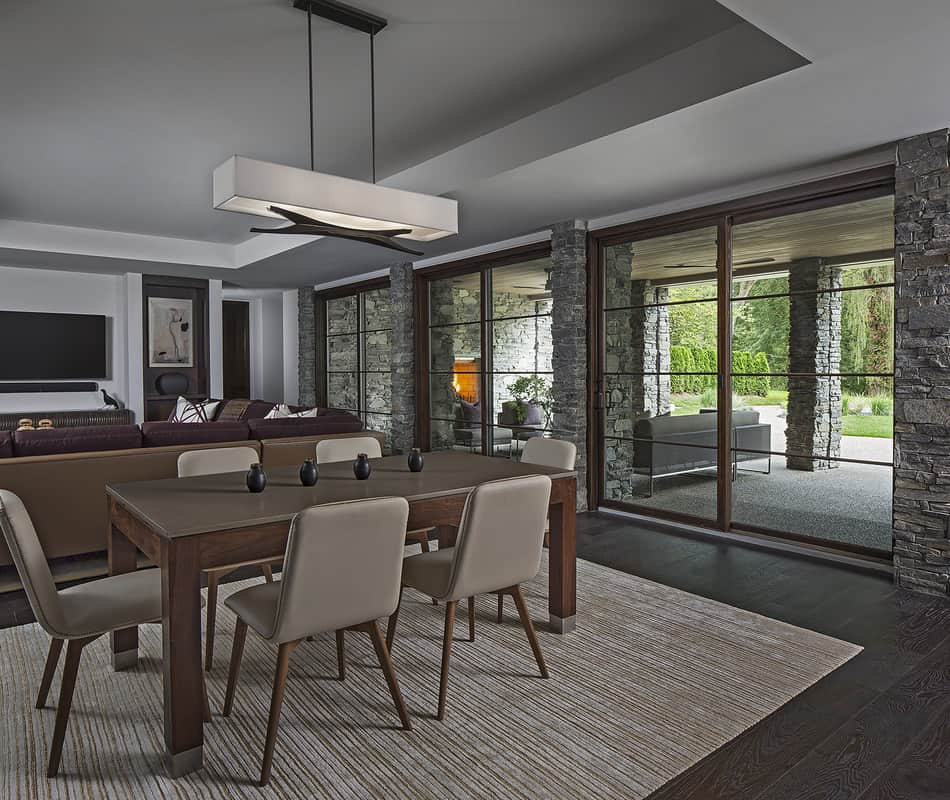 The dining area behind the living room is defined by a large area rug.