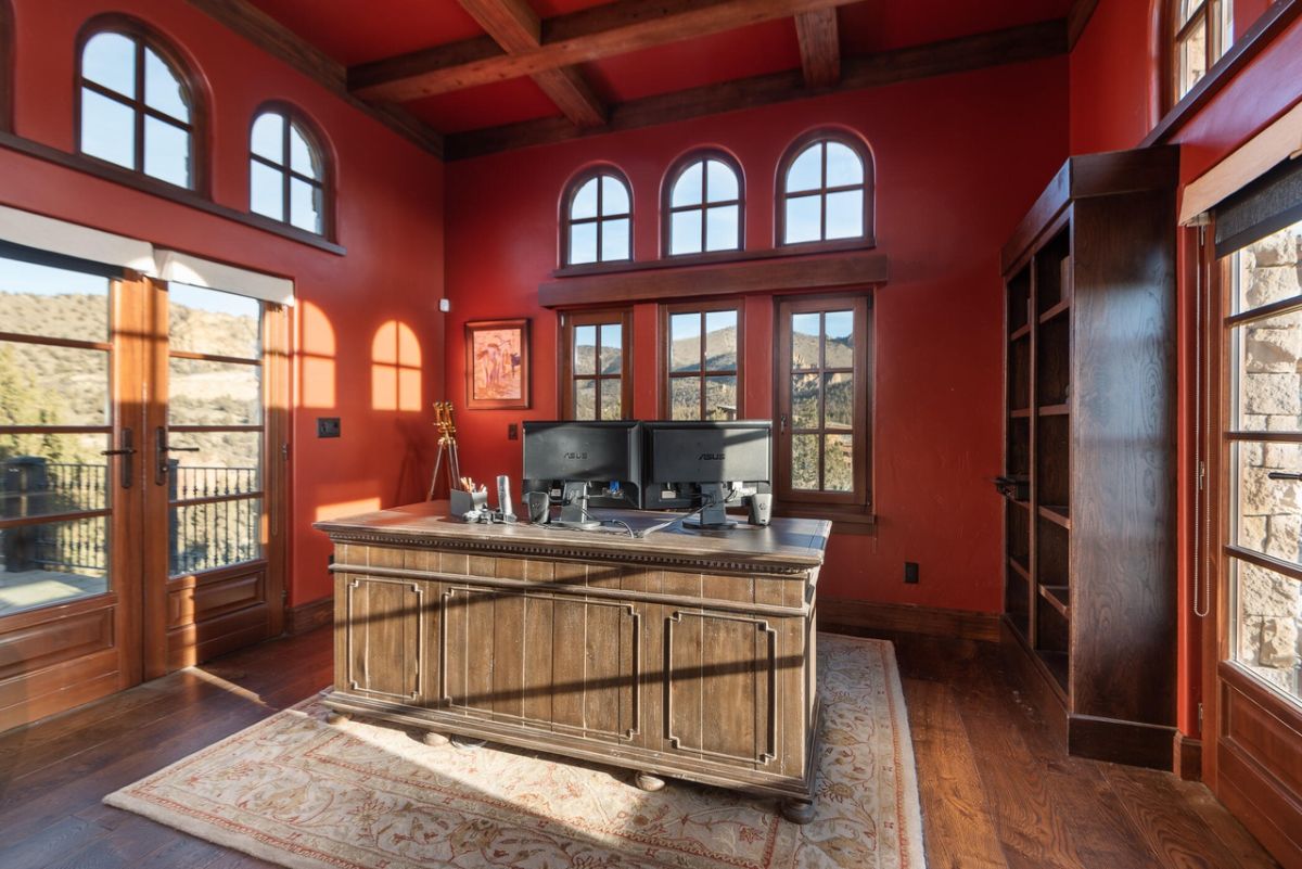 The study features an antique table and access to the terrace for a breather after some work.