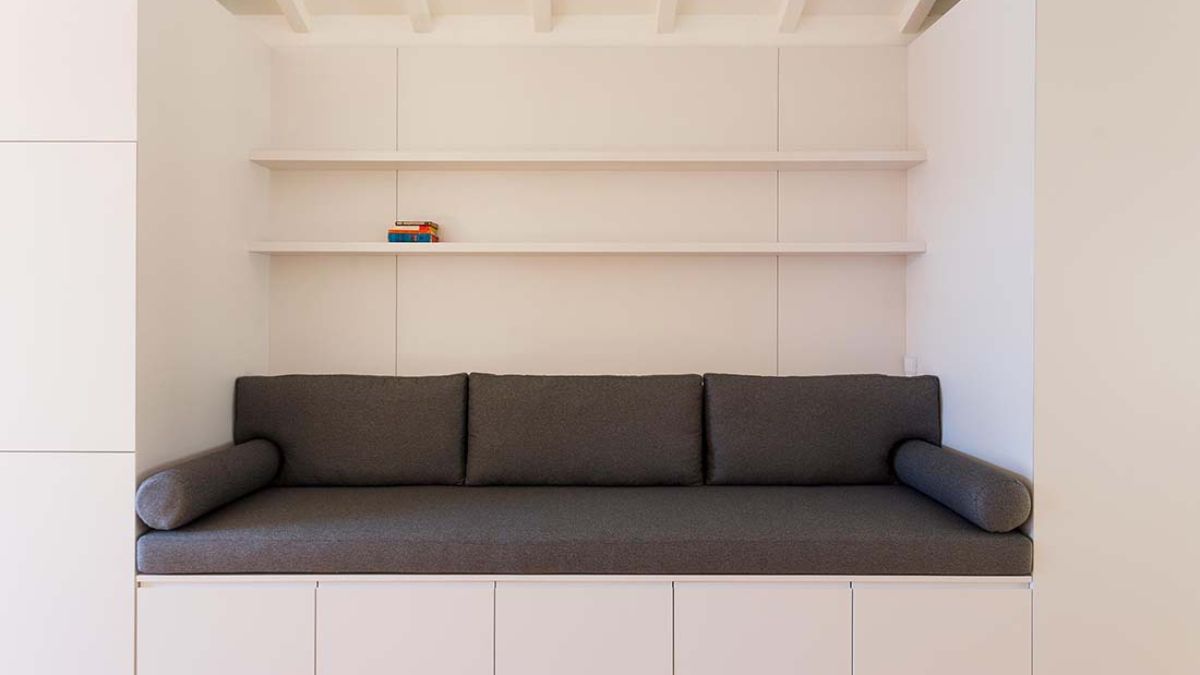 The walls have built-in sofa, and the gray and white colors go well together.