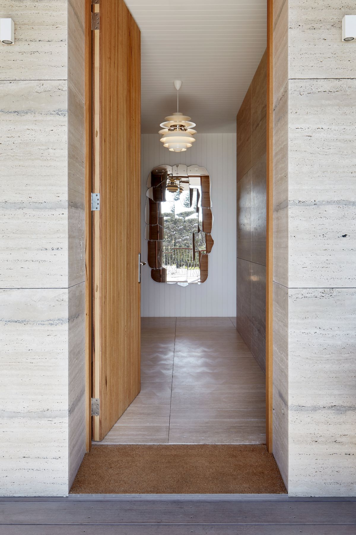 Entry way in a modernist and natural beach home featuring natural toned light unfilled Travertine tiles from G-Lux on both the floor and exterior walls.