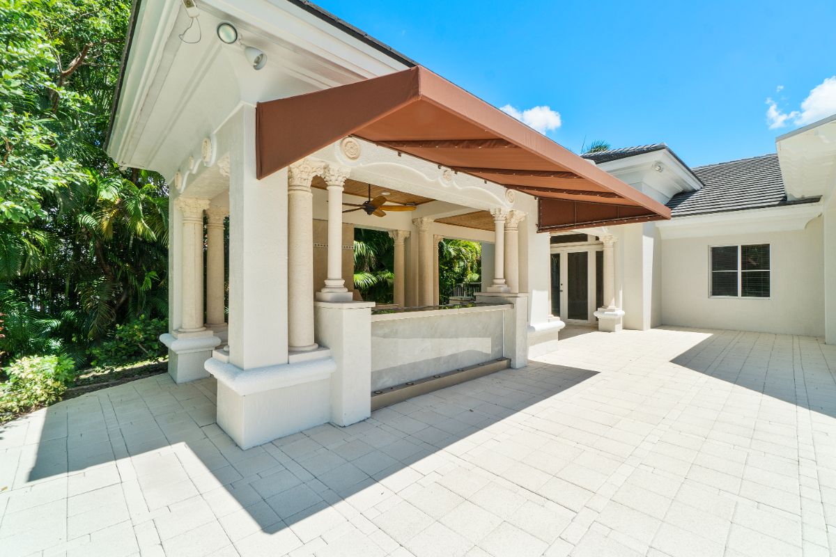 The outdoor kitchen features Corinthian columns, and a roof is installed to shade the counter.