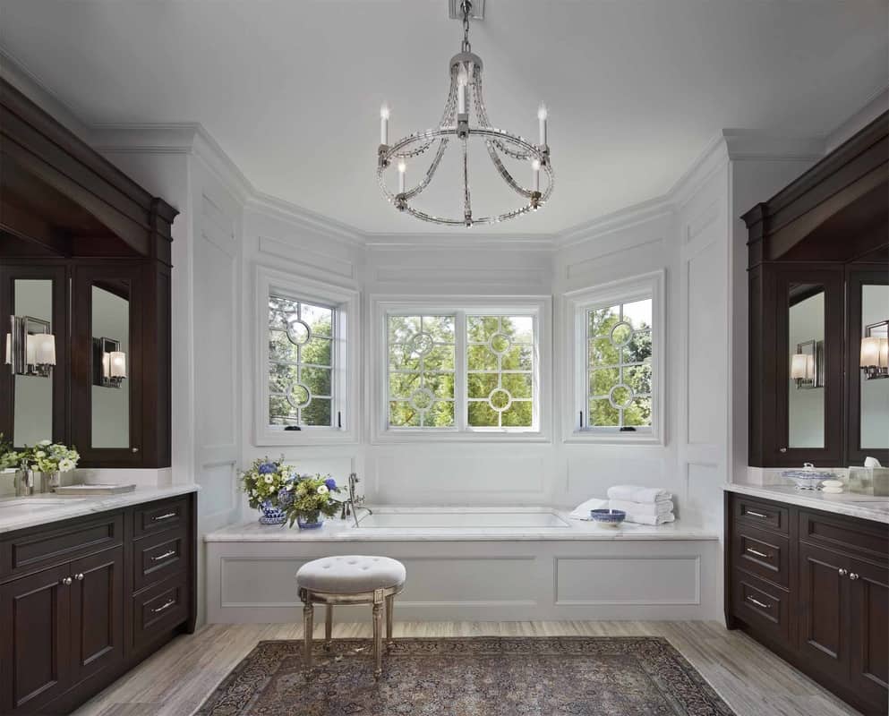 Separate his and her sink vanities flank the drop-in bathtub in the primary bathroom.