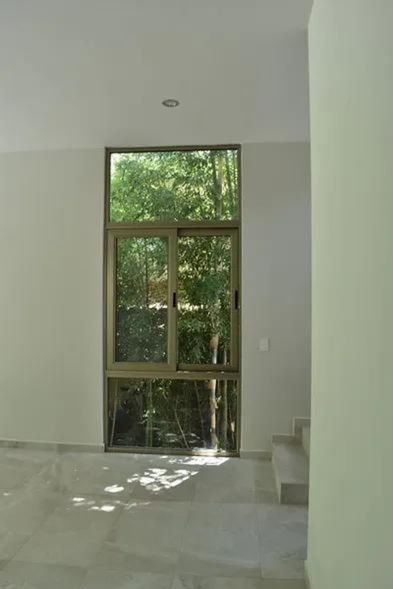 This is an interior photograph that showcases the prominent glass window positioned alongside the staircase.