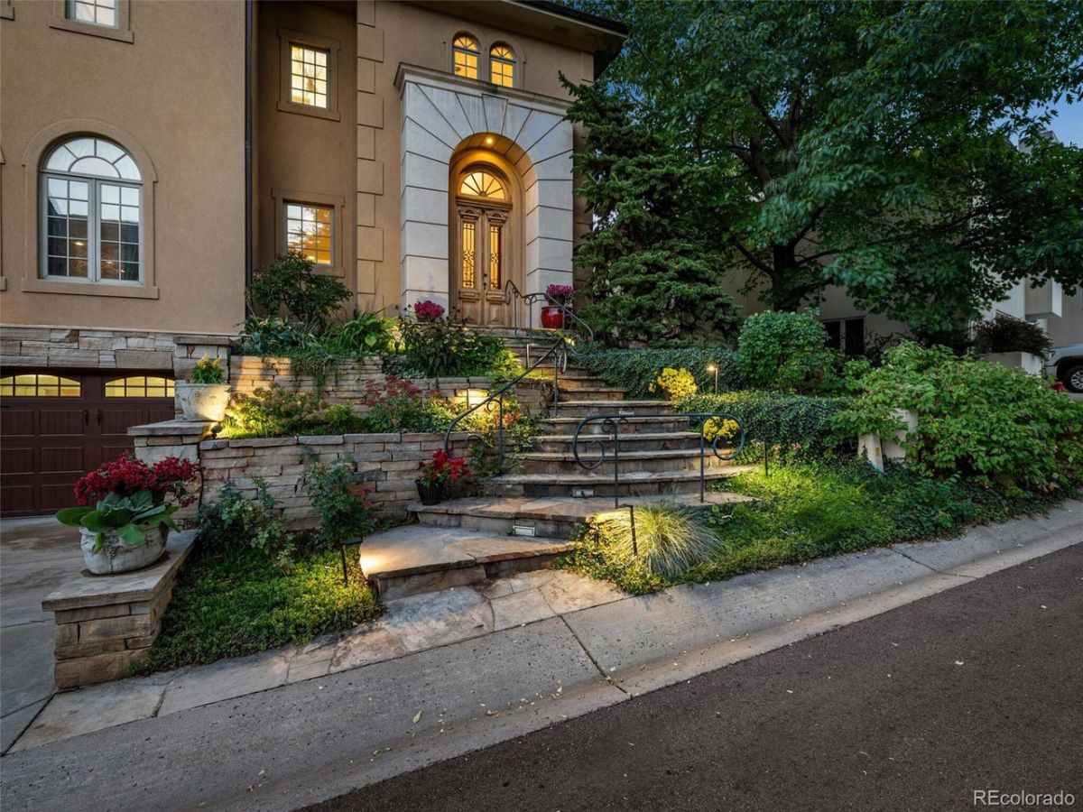 The entrance to the house features an arched porch and stone steps.