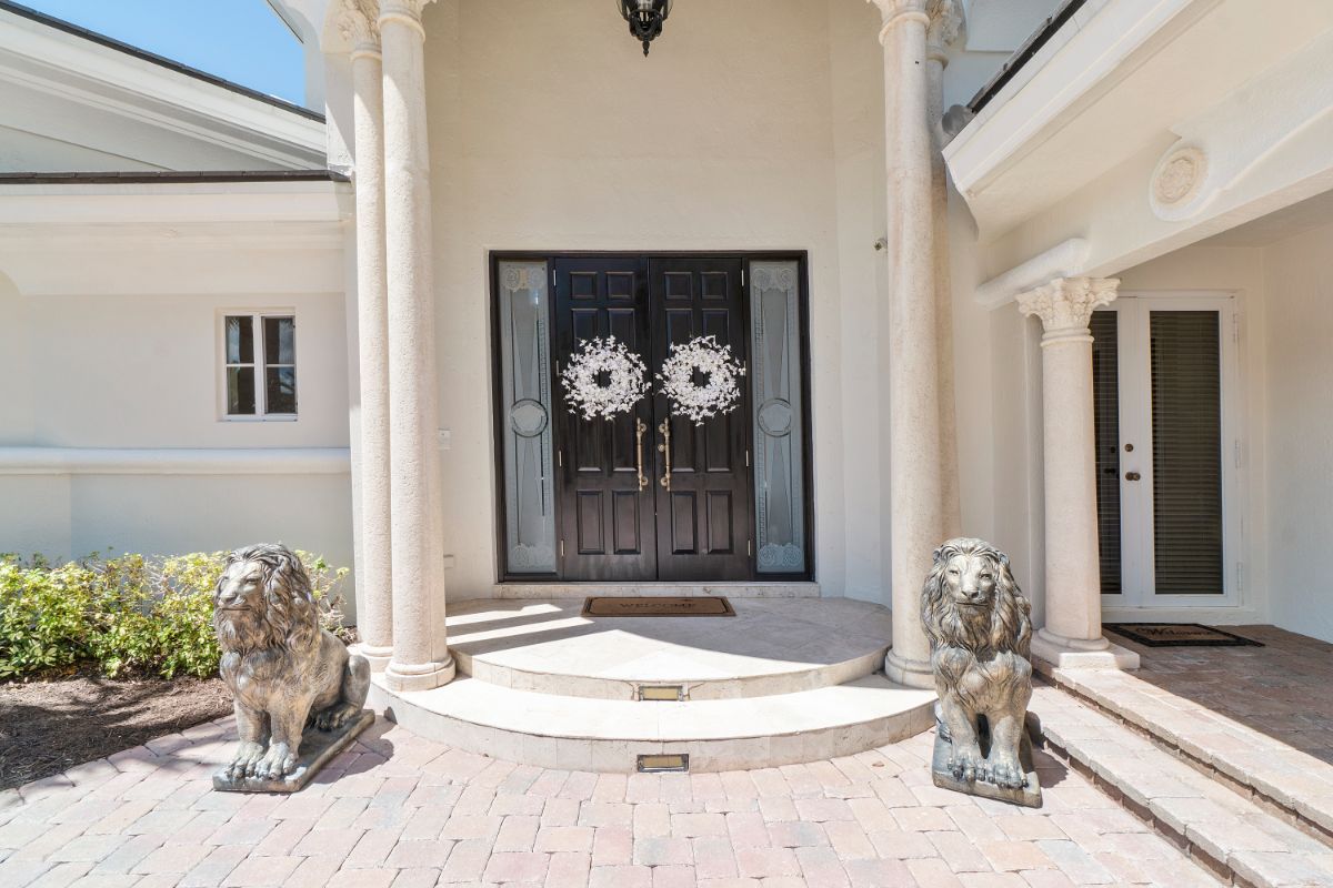 The entrance features lion statues and a porch with Corinthian columns.