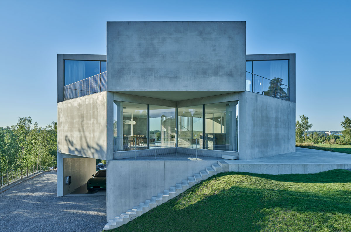 The house is situated on a slope, and a concrete stair was installed leading to the entrance of the house.