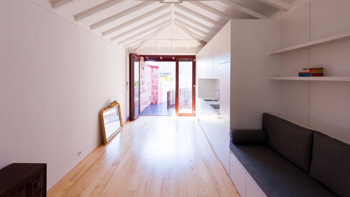 The interior of the house is made out of wooden furnishings, white painted walls, and glass doors.