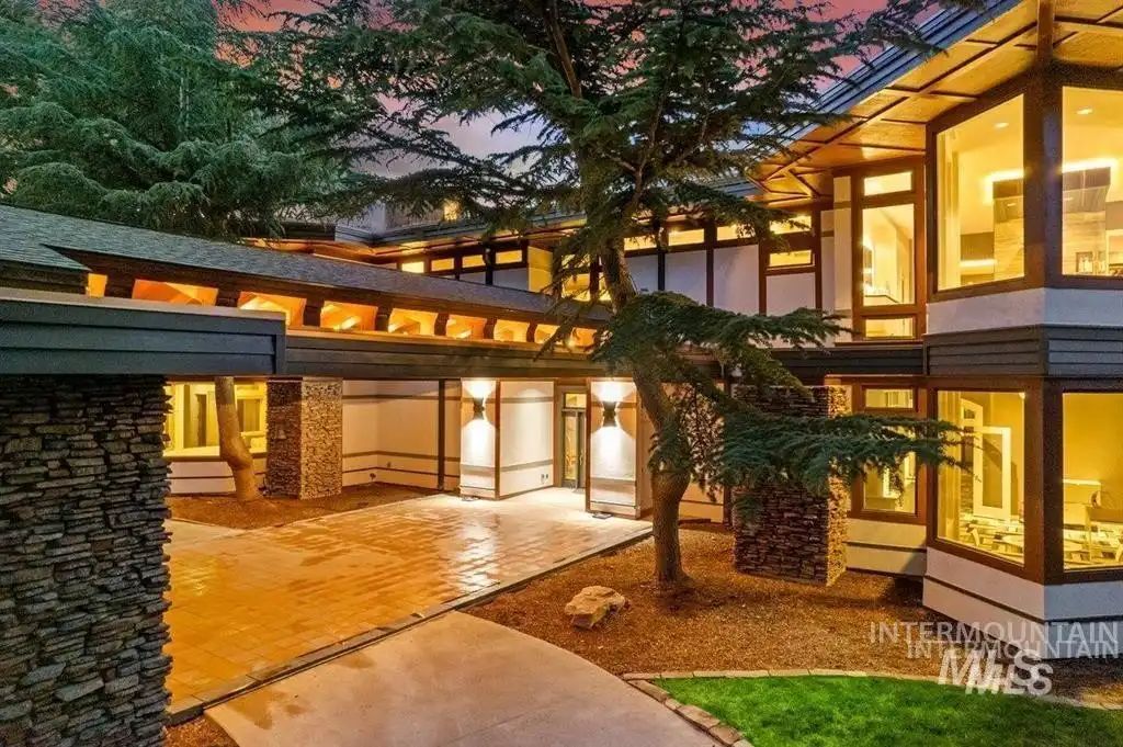 The entrance to the house has stone walls and a concrete walkway.