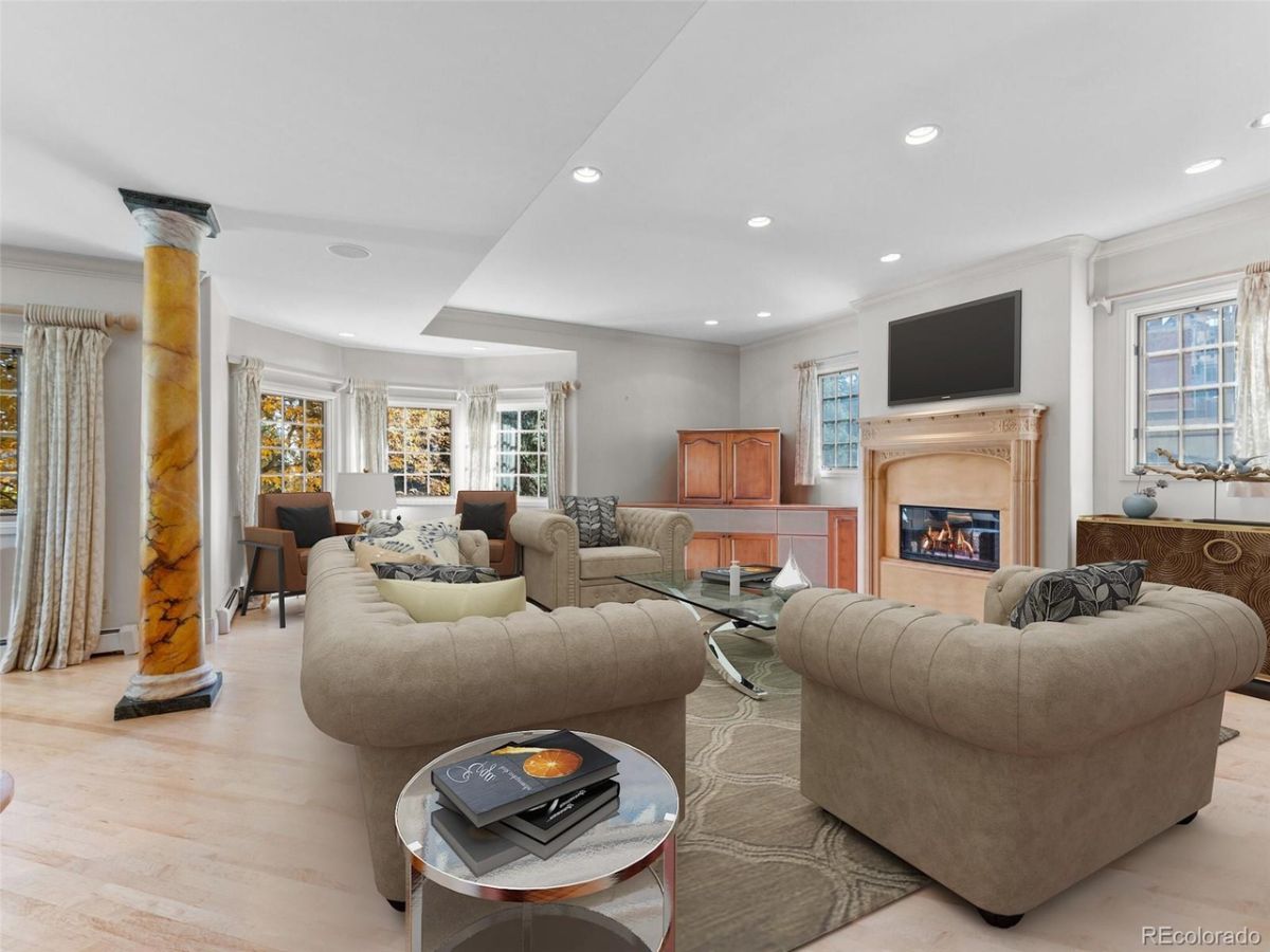 The living area features an electric fireplace and cozy sofas.