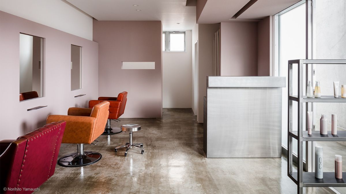 A hair salon with chairs in various colors, an entryway, and a washroom are all located on the first floor.