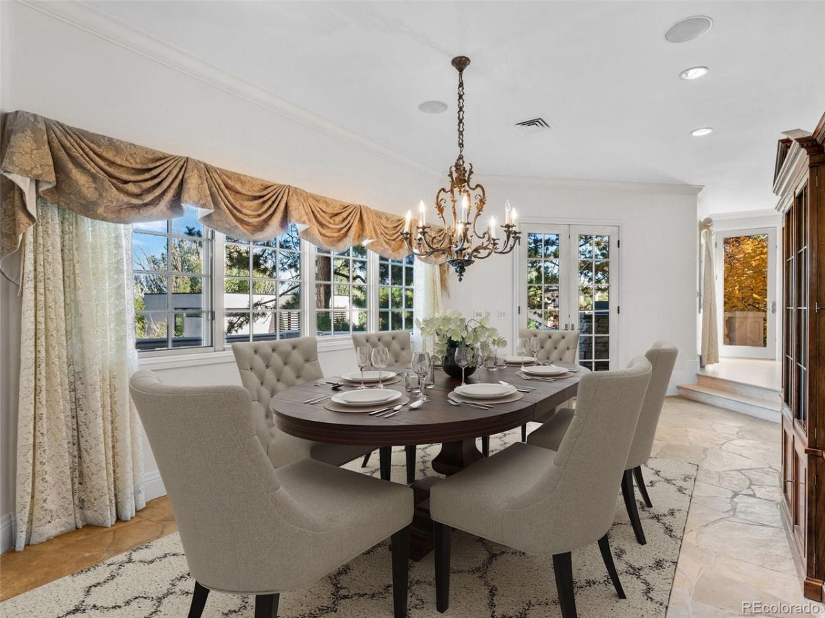 The formal dining room is decorated with beautiful curtains, and the luxurious chandeliers give a dramatic effect.