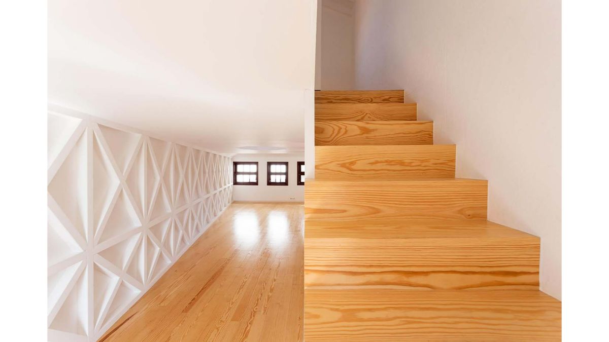 The staircase has a distinctive wooden construction and white walls.