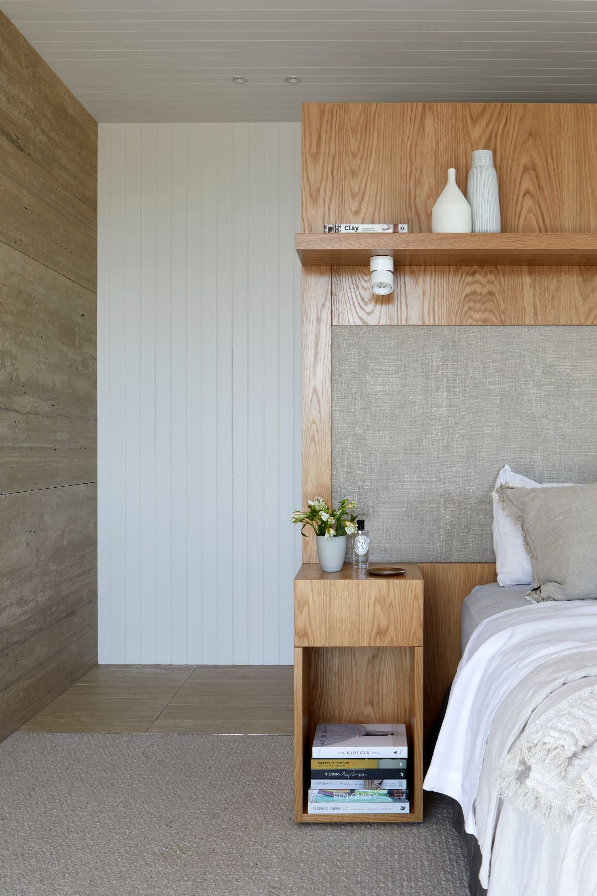 The veneer oak wall blends well with the nightstand in the bedroom, giving a rustic and cozy feel.