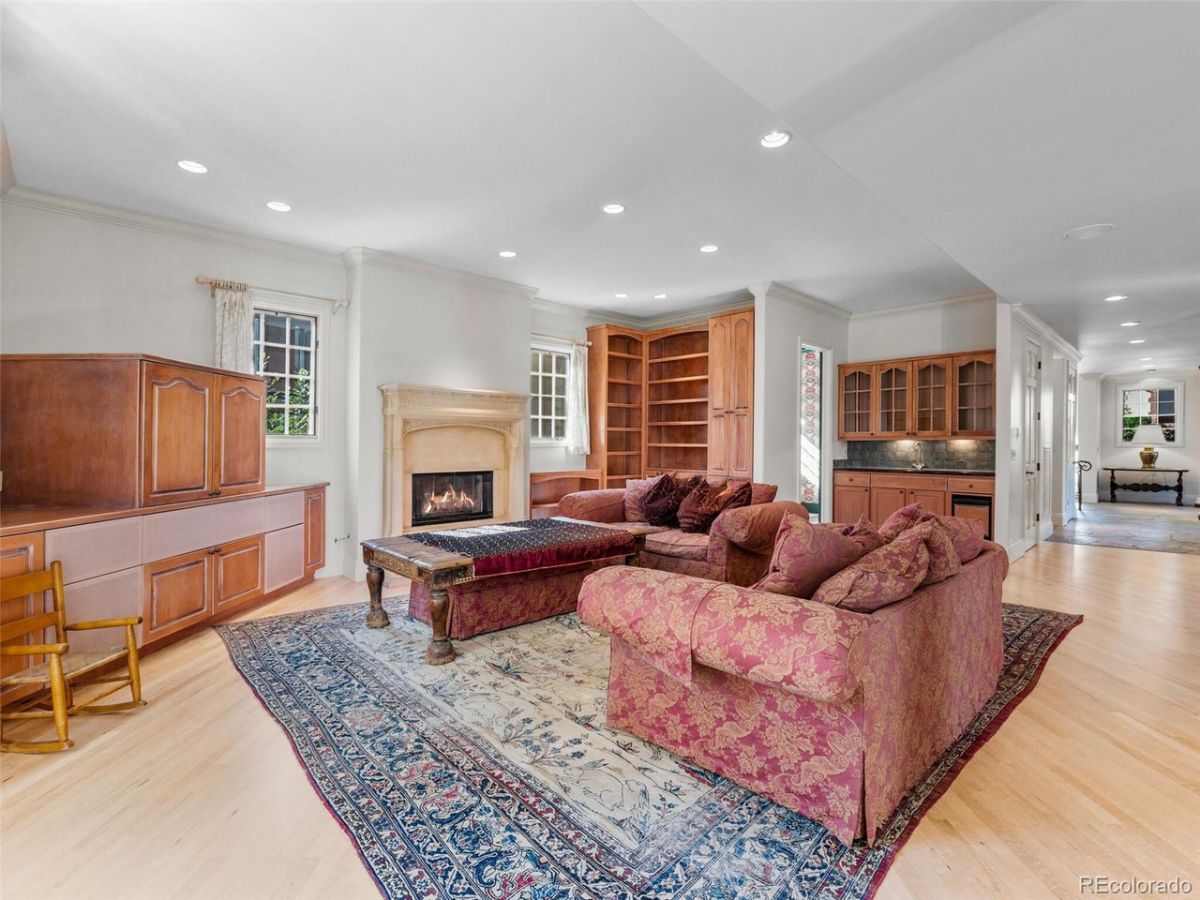 The fireplace area features a sofa and carpet, giving off a cozy feel to the room.