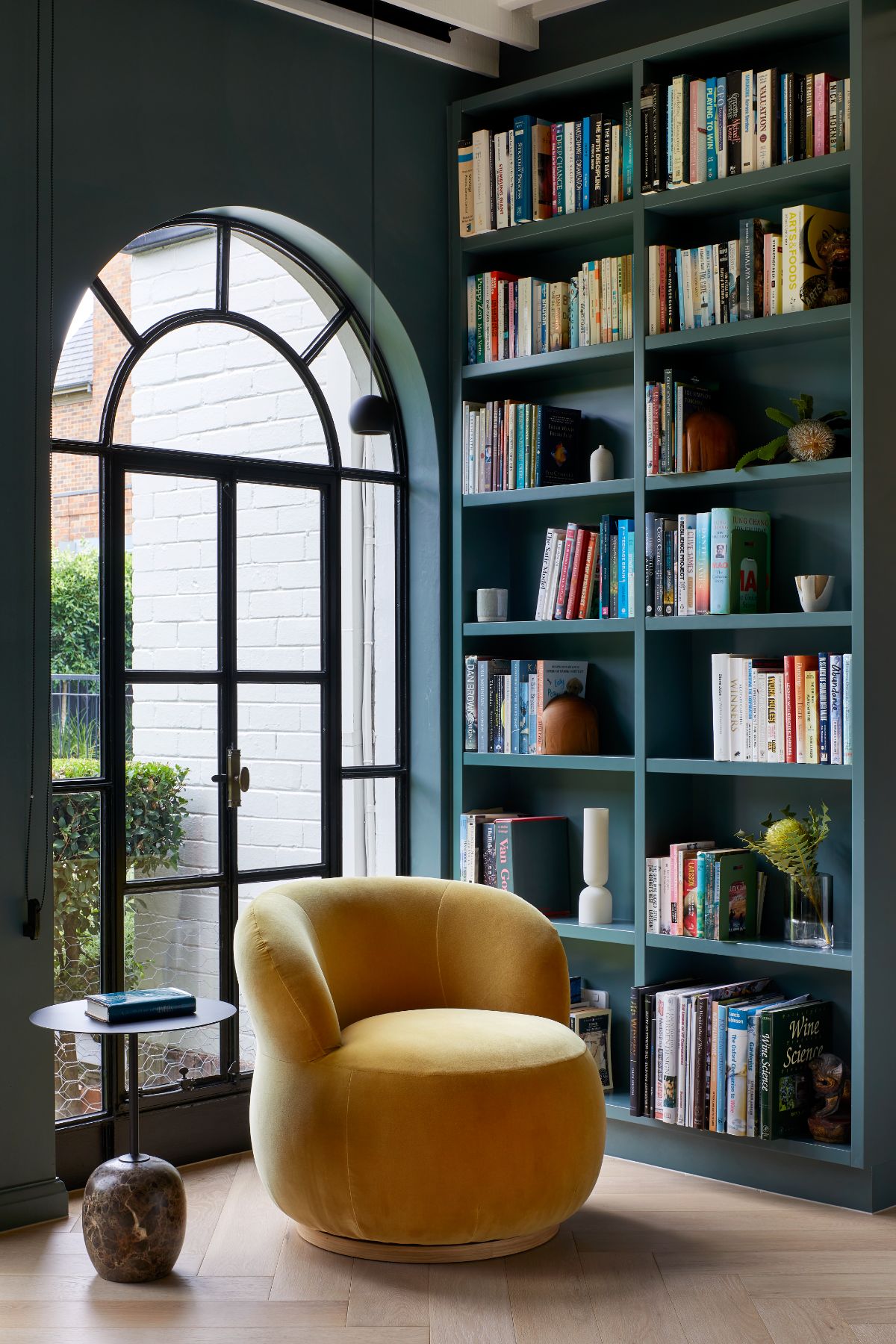 A seat and a coffee table beside the bookshelf.