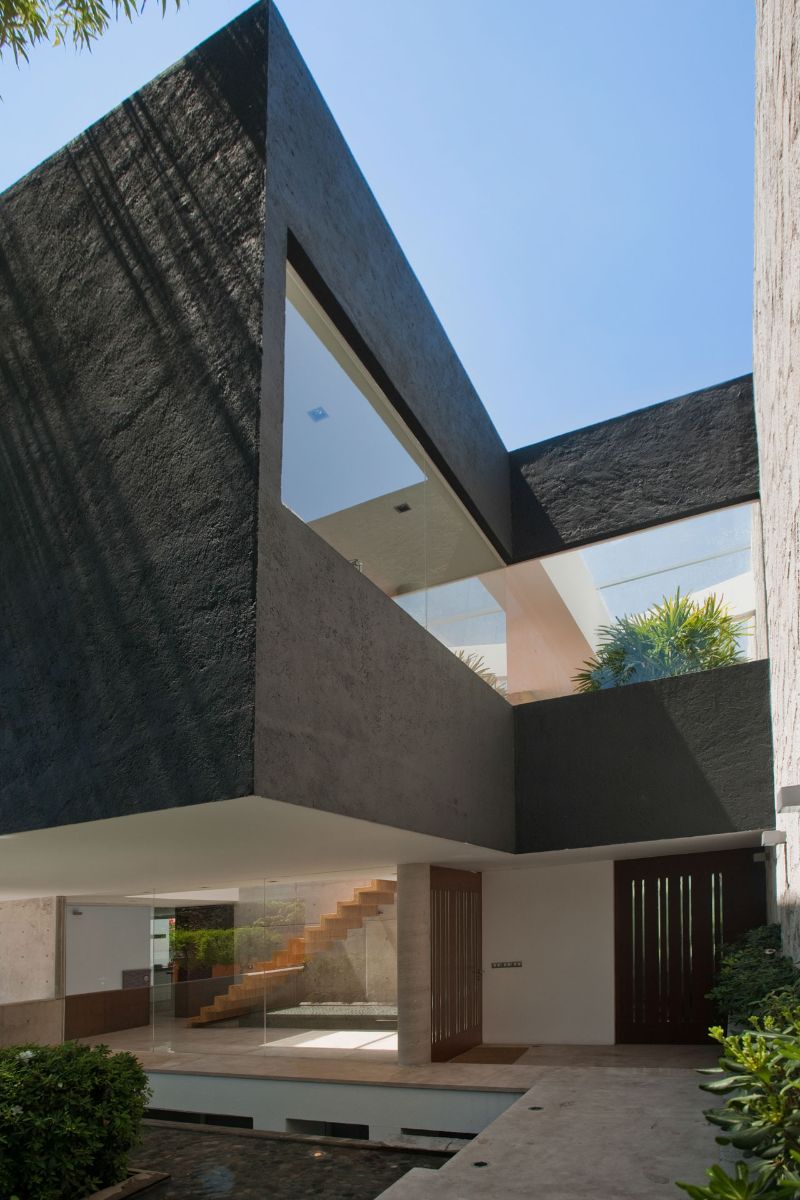 The black prism is supported by the slender columns, which free up the space beneath it.