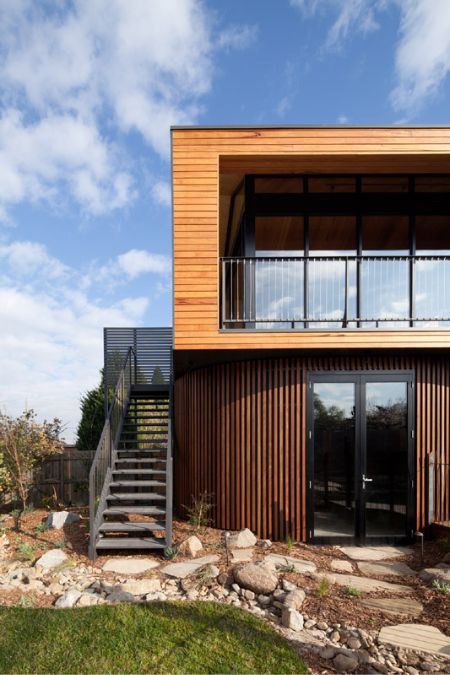 An exterior shot of the house showcasing a part of its front facade architectural design which are made of timbers with a mix of metal details.