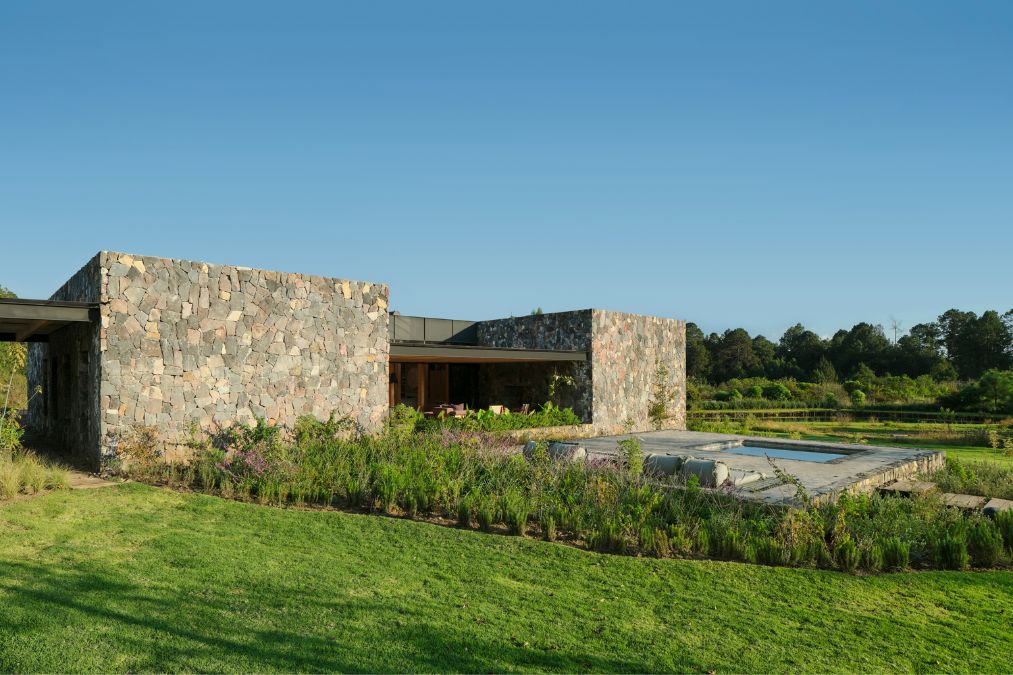 Amidst a field lies the FS House, featuring a central pool.