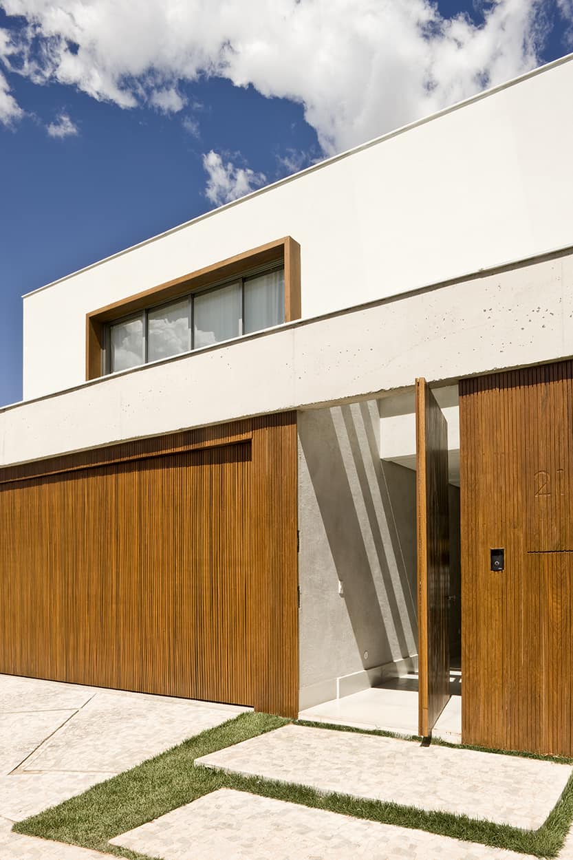 A wooden pivot door welcomes guests inside.