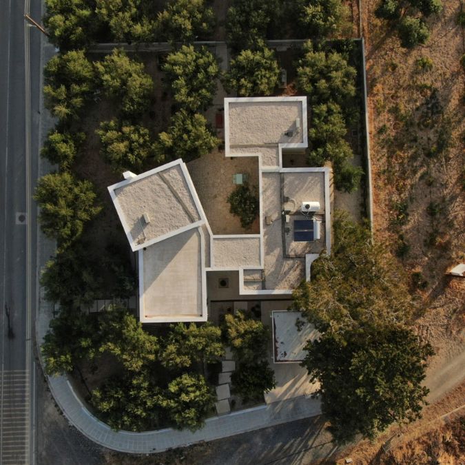 This is an aerial perspective of the residence enveloped by a dense cover of trees.