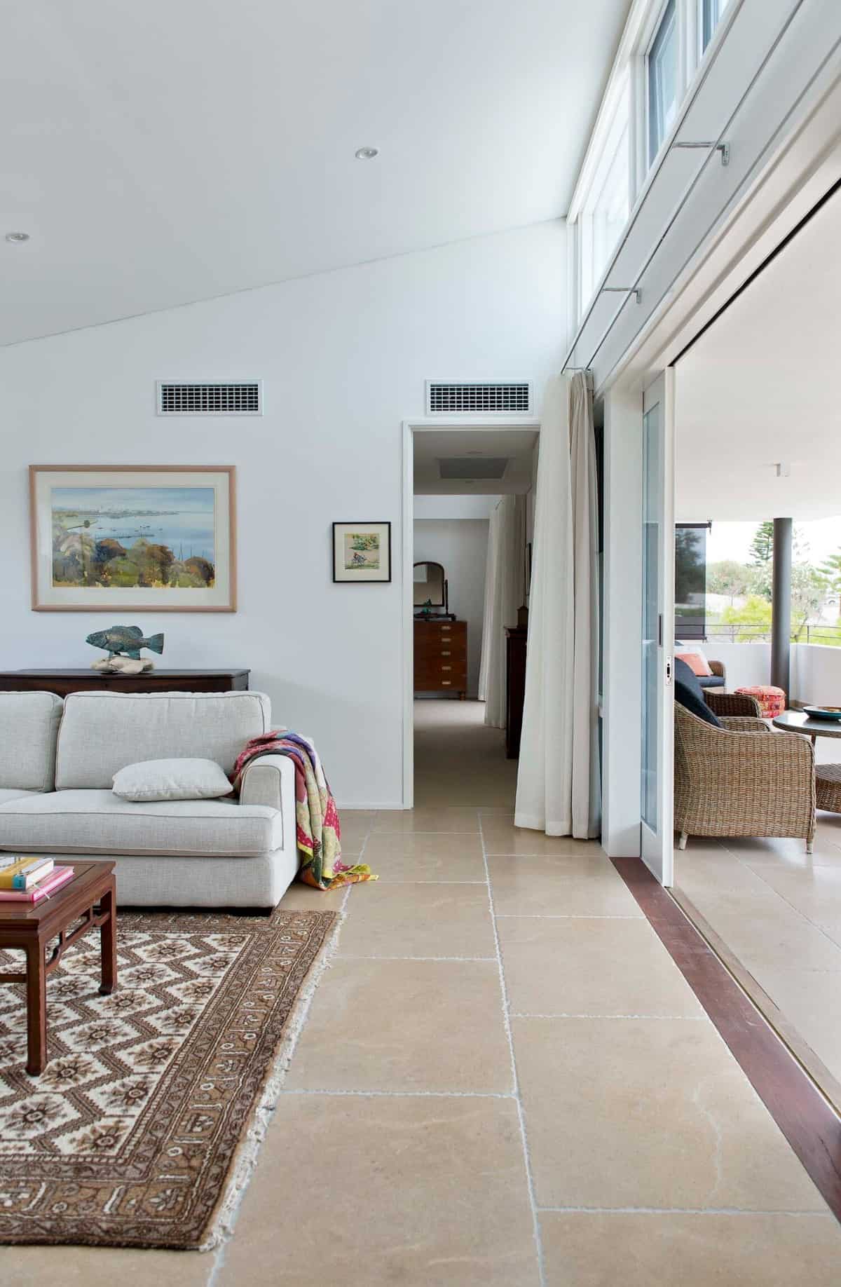 A tall shed ceiling crowns this living space and sliding glass doors extend it onto a covered balcony.