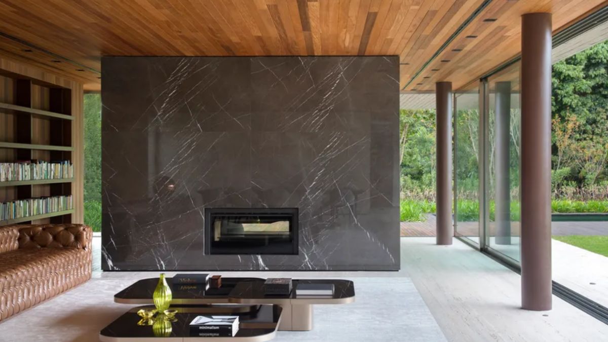 A large marble wall with an integrated fireplace can be found in the serene living space.