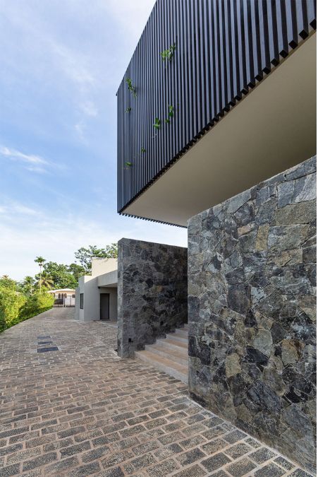 This stunning perspective shot captures the exterior design of the house, showcasing its architectural design, focuses on the pathway that leads to the outdoor stairs.