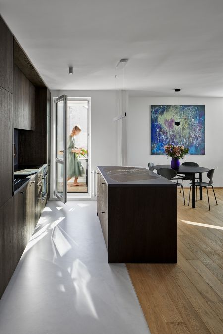 This is a close-up shot of the kitchen section, showcasing a center island and suspended wall-mounted cabinets that are in the same color scheme, creating a visually appealing and harmonious design.