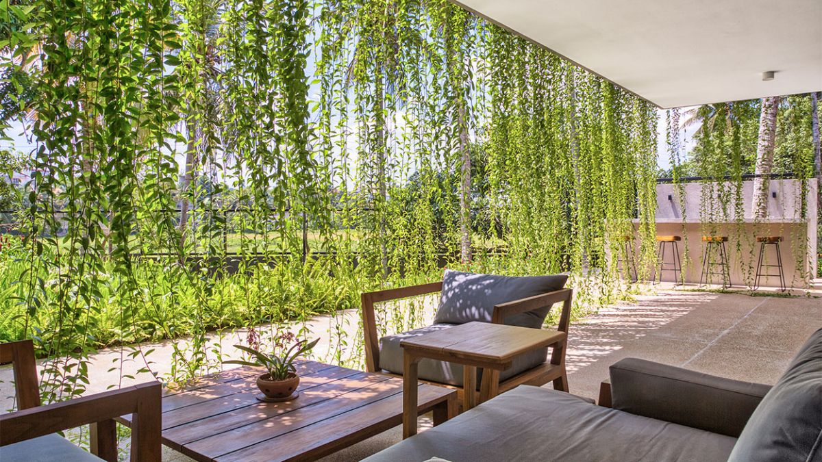 This photograph showcases the outdoor living area of the residence, which is designed to seamlessly blend with the lush garden surroundings.