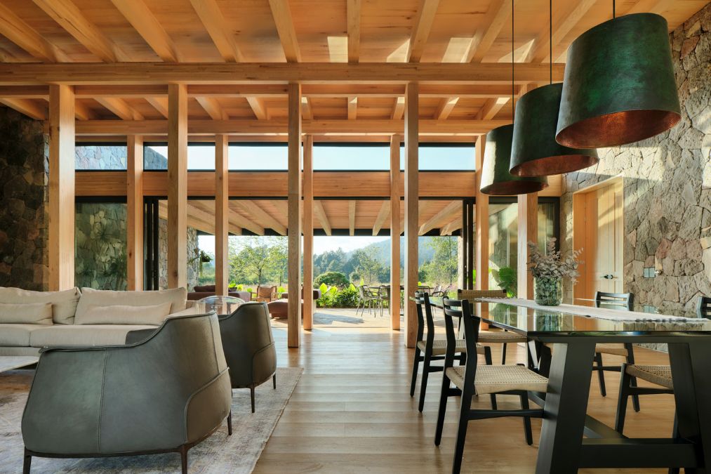 The living room is fully furnished and accentuated by a stone wall.