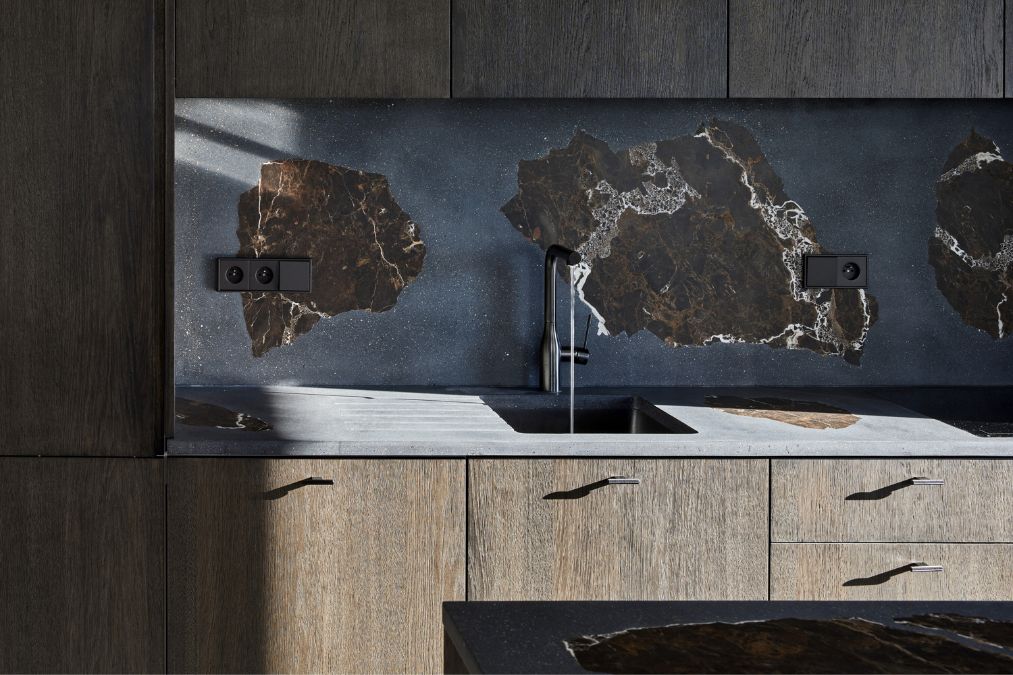 This is a close-up shot of the kitchen sink area, where three rustic elements are visible on the wall, adding a unique design feature to the space.