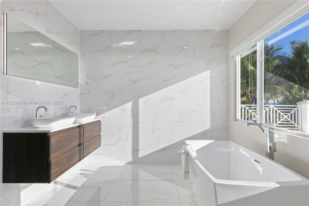 The master bathroom features a free-standing bathtub and a floating vanity.