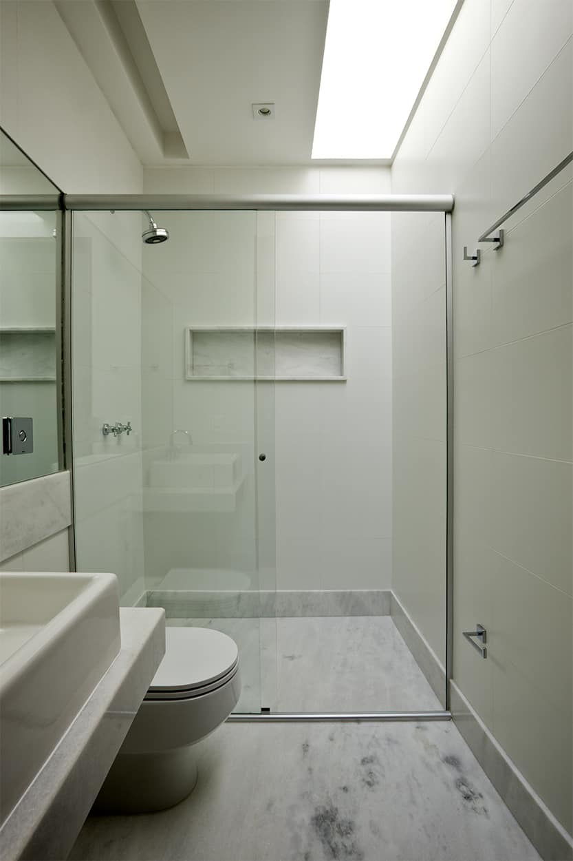 This bathroom has a marble floor and a linear skylight.