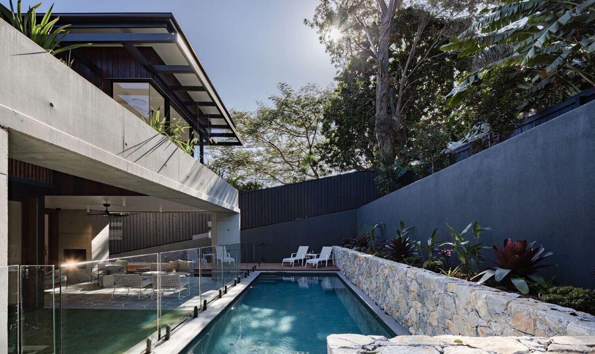 Long and narrow swimming pool with a terrace view.