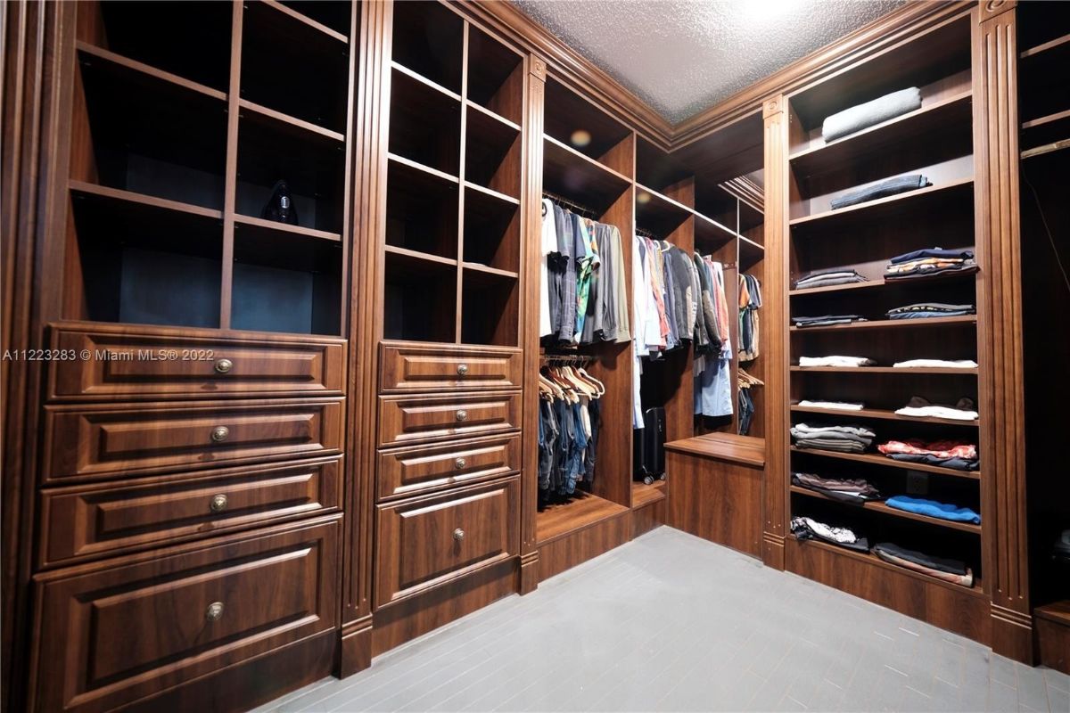 The walk-in closet features tile flooring, and the wooden cabinet gives a rustic feel.